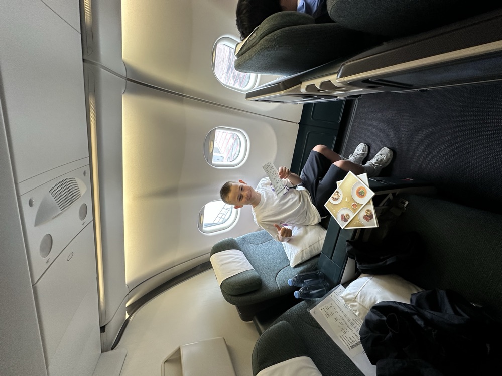Kind sitzt entspannt in der Business Class